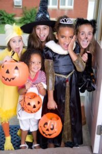 A group of children in costumes trick-or-treating on Halloween.