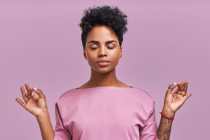 Calm woman relaxing meditating, no stress free relief at work concept, mindful peaceful young businesswoman or student practicing breathing yoga exercises on isolated over lavender background.